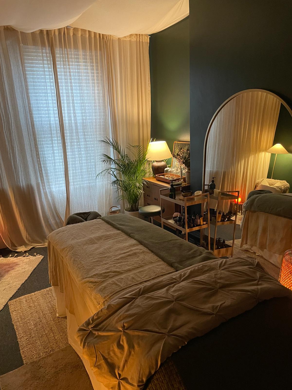 Sheer curtains filtering soft afternoon light across the treatment table.