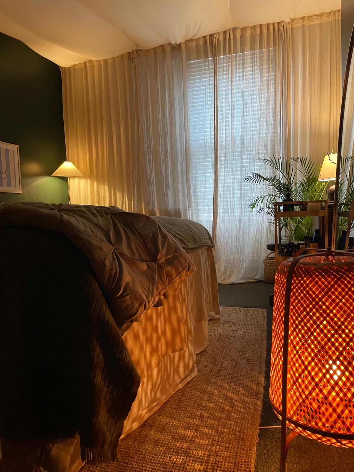 Rattan lantern glowing warm amber in the corner of the studio.