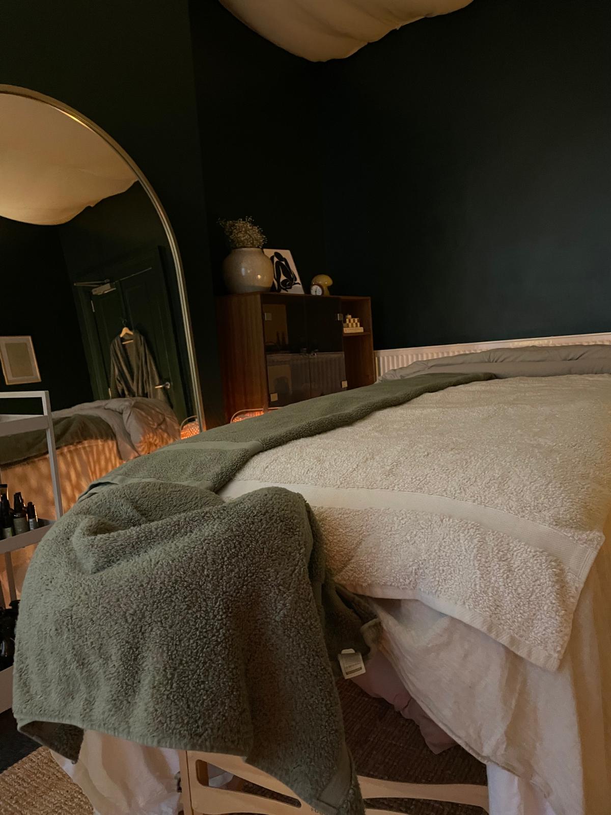 Sage fleece throw and cream boucle blanket folded on the table.